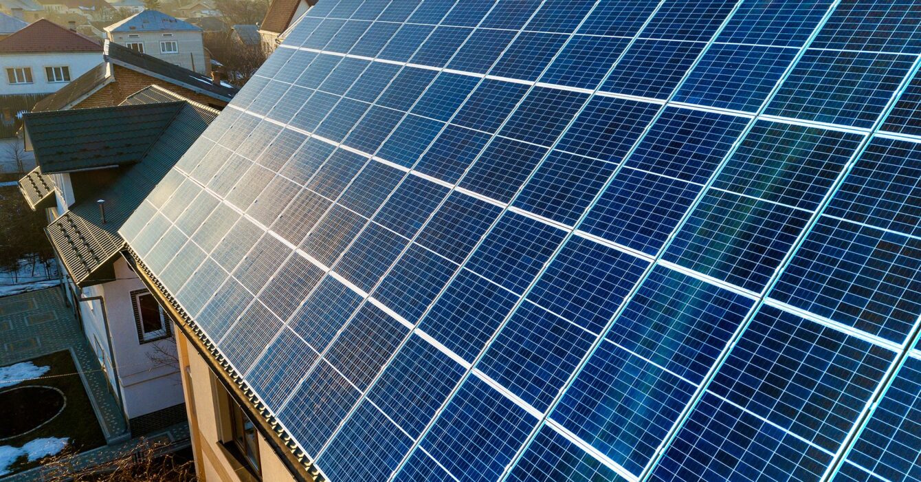 aerial-view-new-modern-two-story-house-cottage-with-blue-shiny-solar-photo-voltaic-panels-system-roof-renewable-ecological-green-energy-production-concept aerial-view-new-modern-two-story-house-cottage-with-blue-shiny-solar-photo-voltaic-panels-system-roof-renewable-ecological-green-energy-production-concept