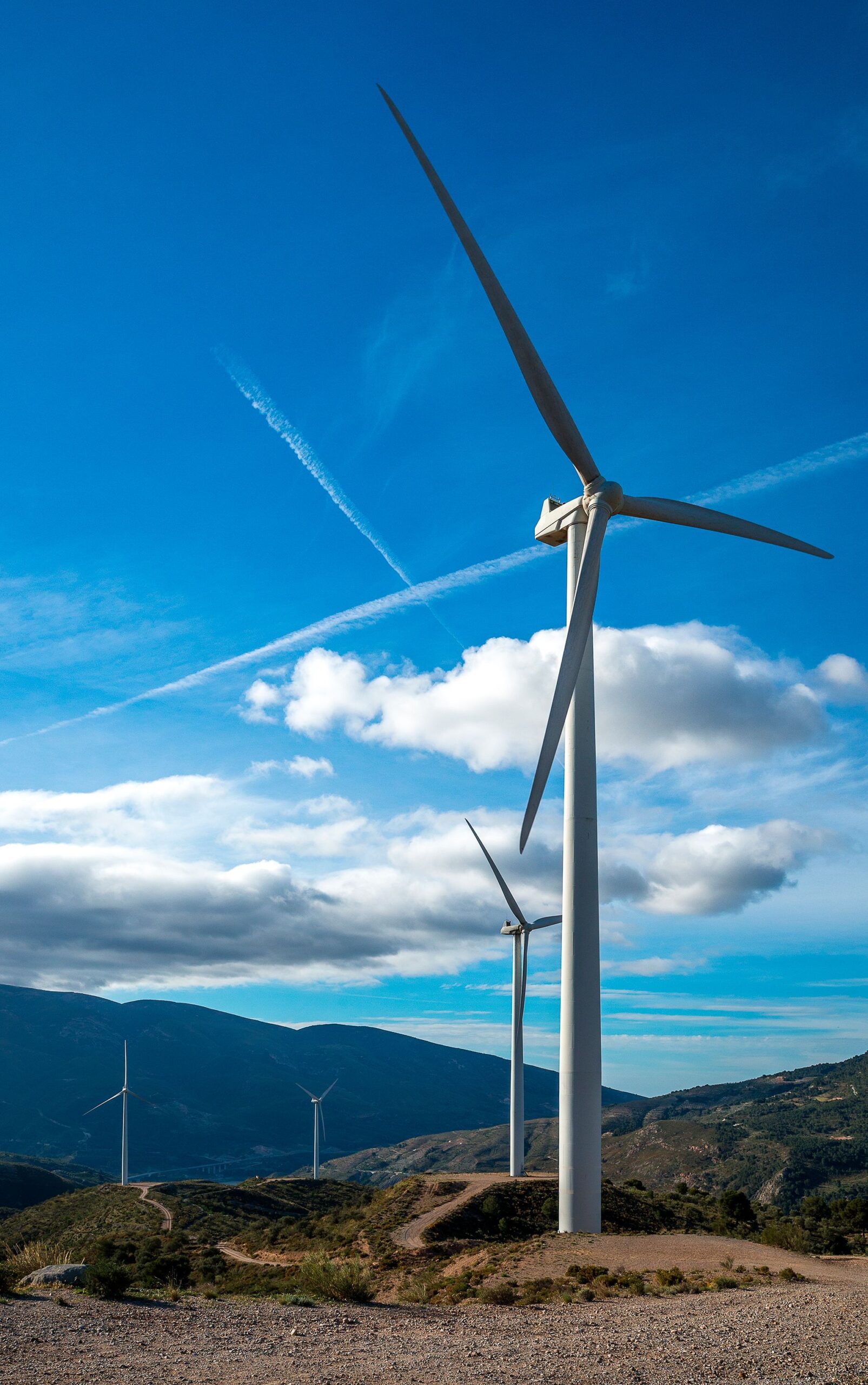 vertical-shot-several-white-electric-windmills-hill vertical-shot-several-white-electric-windmills-hill